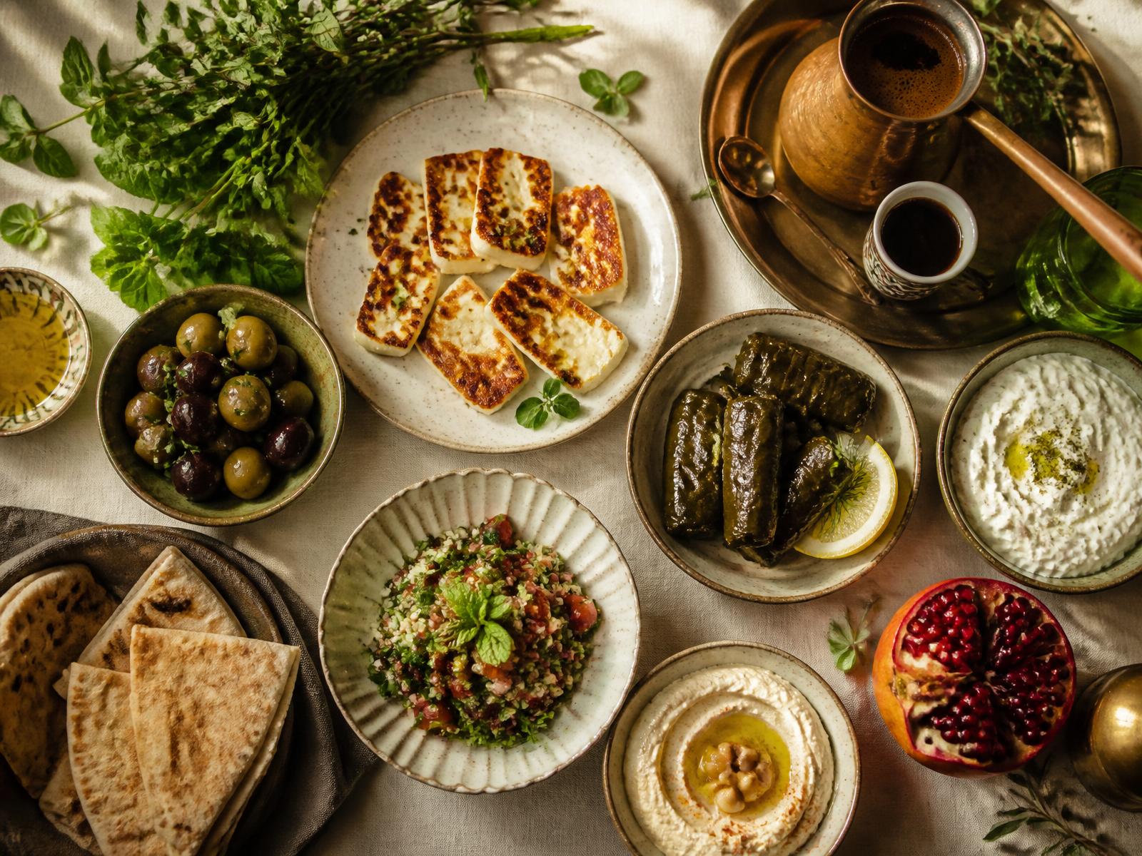 A traditional Cypriot mezze spread with halloumi, olives, dolmades and pomegranate.